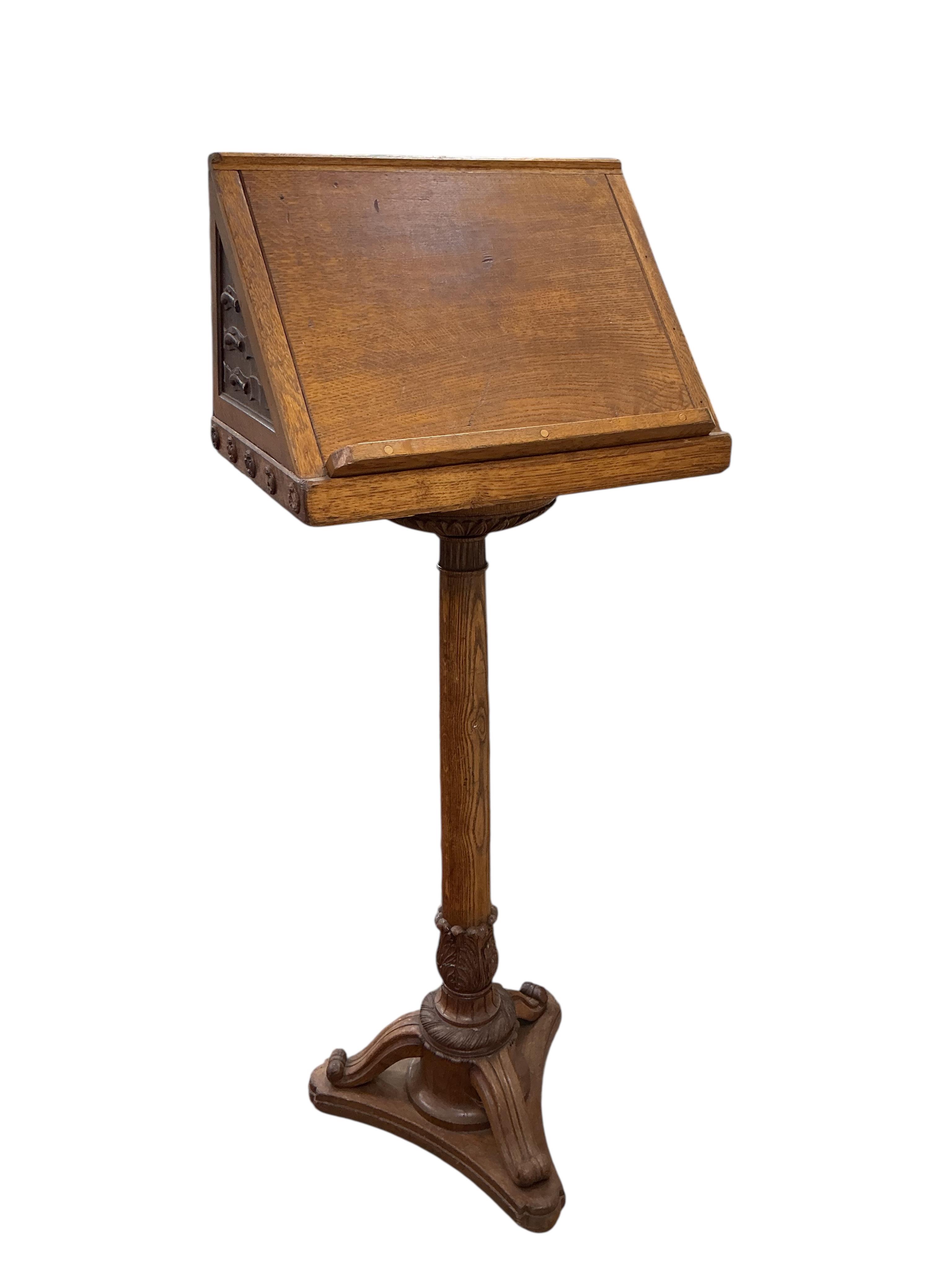 A mid 20th century oak lectern carved with ribbon fold floral swag and the legend “Rolfe George Martin, M.A (Cantab), First Headmaster of The School, 1924 - 1947. Height 142cm.